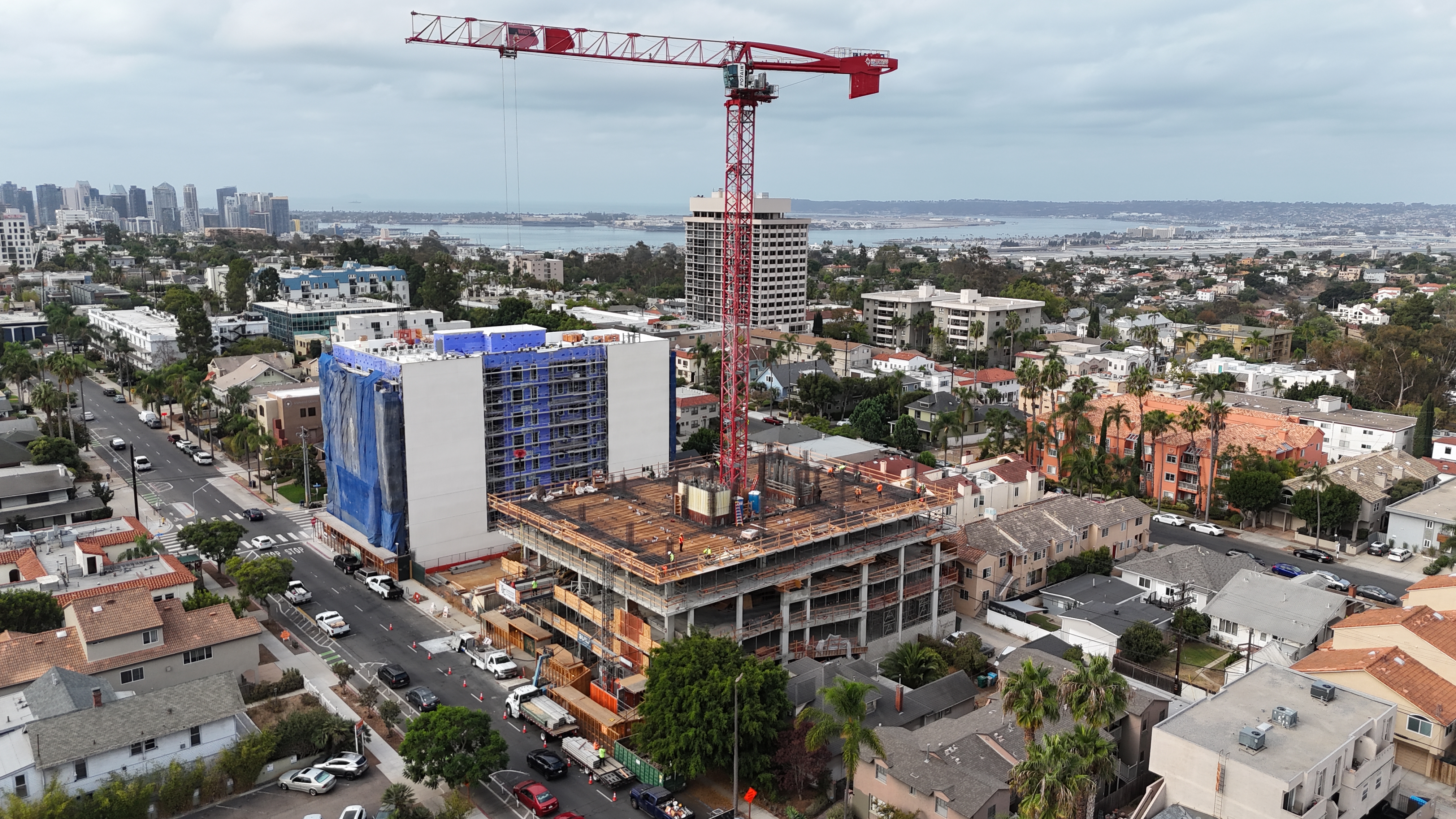 Aerial view of an active ground-up construction site with a tower crane
